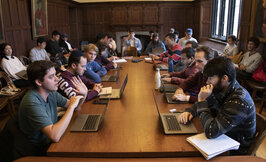 students with computers at a large table