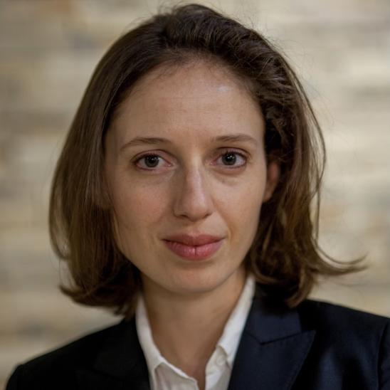 Headshot of a woman with shoulder-length hair in a black suit jacket and white shirt