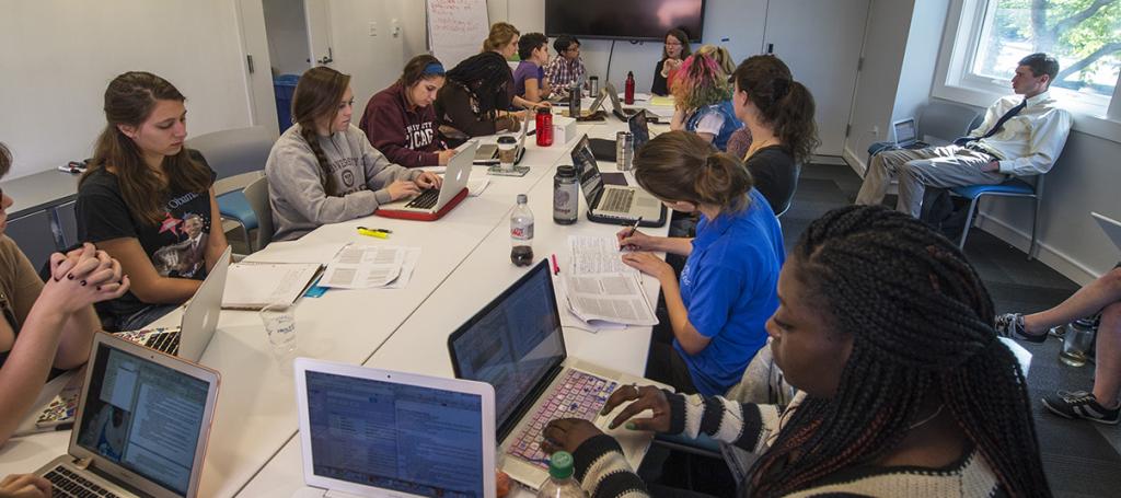 People seated at a table with laptops.